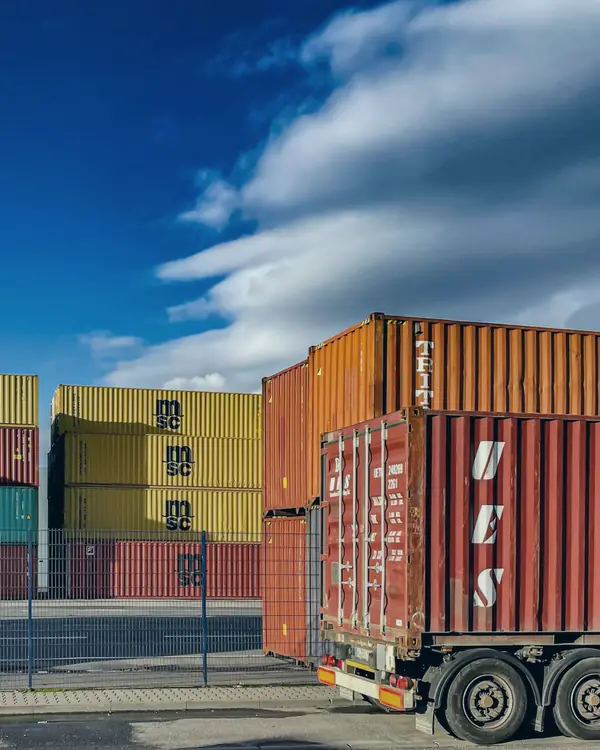 Contenedores y camión de carga en una terminal portuaria